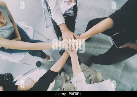 Nahaufnahme, Ansicht von oben Young Business Menschen die Hände zusammen. Stapel von Händen. Einheit und Teamarbeit Konzept. Stockfoto