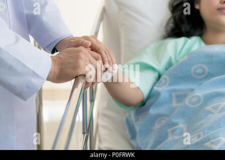 Freundliche mann Arzt Hände halten patient Hand am Schreibtisch für Ermutigung sitzen, Einfühlungsvermögen, Jubel und Unterstützung während der ärztlichen Untersuchung. Schlechte neue Stockfoto