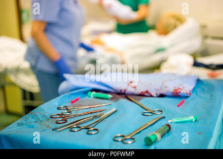 Silver Frauenarzt Werkzeuge während der Geburt und die Mutter und das Krankenhauspersonal im Hintergrund verwendet Stockfoto