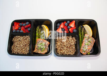 Geplante Mahlzeiten in den Behältern - Lachs mit Spargel, Quinoa und frisches Obst. Stockfoto