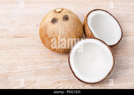 Reif halb Kokosnuss auf einem hölzernen Hintergrund. Stockfoto