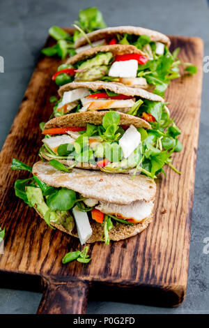 Pita Sandwiches, gefüllt mit Hühnerfleisch, Gemüse und Käse auf Holz Schneidebrett. Stockfoto