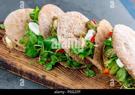Pita Sandwiches, gefüllt mit Hühnerfleisch, Gemüse und Käse auf Holz Schneidebrett. Stockfoto