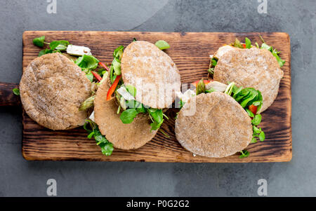 Pita Sandwiches, gefüllt mit Hühnerfleisch, Gemüse und Käse auf Holz Schneidebrett. Stockfoto