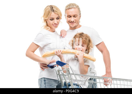 Kleinen Jungen essen Brot während der Sitzung in Warenkorb mit den Eltern in der Nähe von Weiß isoliert Stockfoto