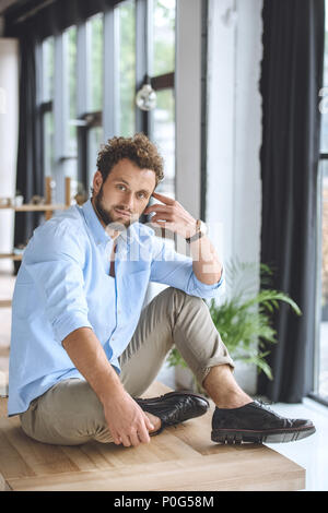 Nachdenkliche junge Unternehmer sitzen am Tisch in modernen Büro Stockfoto