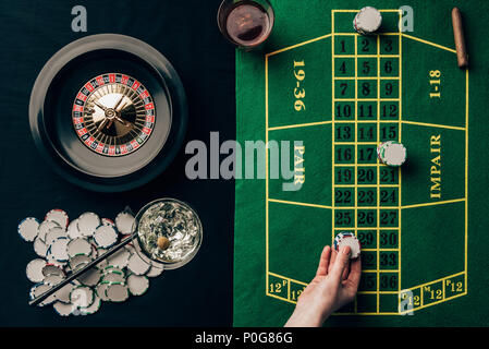 Frau man platziert einen Einsatz auf Tisch mit Roulette Stockfoto