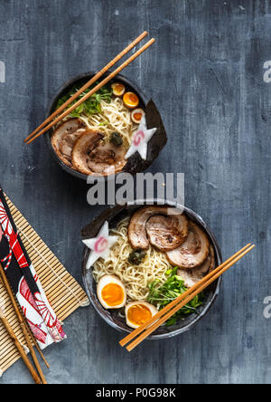 Zwei ramen Schüsseln mit Schweinefleisch, Eier- und Schnittlauch, Ansicht von oben Stockfoto