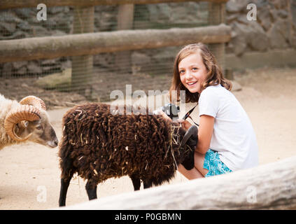 Junge Mädchen in der Farm mit kleine Ziege Stockfoto