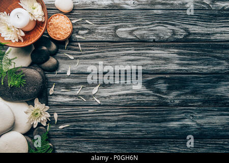 Flach mit Spa und Massage Anordnung mit Kieselsteinen, Salz und Chrysantheme Blumen auf hölzernen Tischplatte Stockfoto