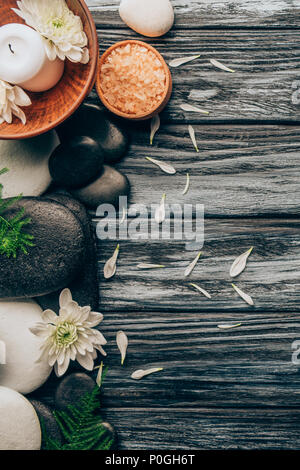 Flach mit Spa und Massage Anordnung mit Kieselsteinen, Salz und Chrysantheme Blumen auf Holz- Hintergrund Stockfoto