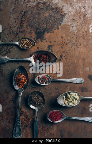Blick von oben auf die Gewürze in Löffel auf grunge Tischplatte Stockfoto