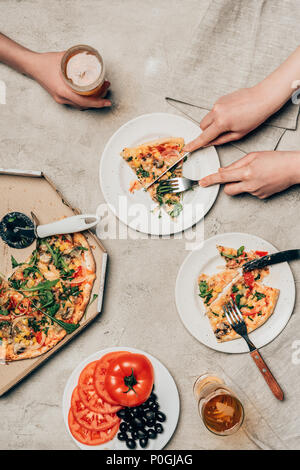Nahaufnahme der Freunde teilen Pizza und Getränk auf hellen Hintergrund Stockfoto