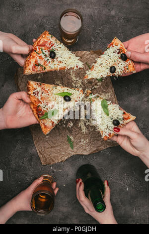 Nahaufnahme der Freunde teilen Pizza und Getränken auf dunklem Hintergrund Stockfoto
