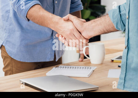 7/8 shot der Unternehmer die Hände schütteln Nach dem Treffen am Arbeitsplatz Stockfoto