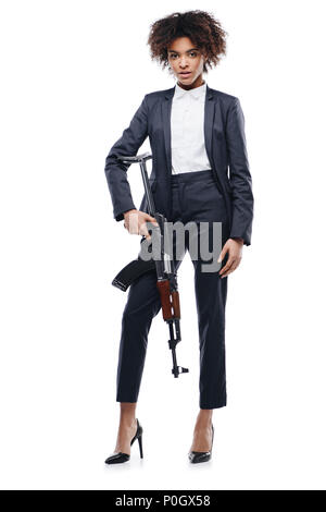 African American weiblichen Spion in Anzug mit Gewehr, isoliert auf weißem Stockfoto