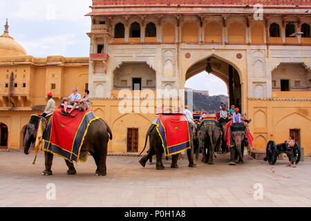 Dekoriert Elefanten mit Touristen zu Fuß durch Suraj Pol (Sun Gate) in Amber Fort, Rajasthan, Indien. Elefantenreiten sind beliebte Touristenattraktion Stockfoto