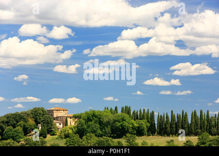 Haus von Bäumen im Val d'Orcia, Toskana, Italien umgeben. Im Jahr 2004 wird die Val d'Orcia wurde von der UNESCO in die Liste des Weltkulturerbes aufgenommen Stockfoto