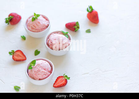 Erdbeereis und frische Erdbeeren auf weißem Hintergrund, kopieren. Drei Becher Erdbeereis, gesunden Sommer Nachtisch. Stockfoto