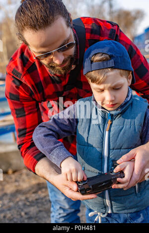 Vater und Sohn holding Fernbedienung Steuerknüppel und Pilotierung quadrocopter Stockfoto