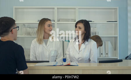 Das medizinische Personal arbeiten um Busy medizinische Rezeption Stockfoto