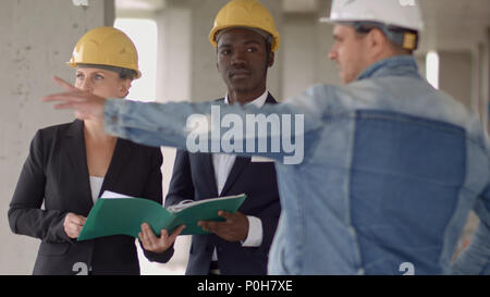 Geschäft Leute Gruppe auf Konferenz und Präsentation in der Baustelle mit Bauingenieur Architekt und Arbeiter aussehendes Gebäude Modell und plan plan plan Pläne Stockfoto