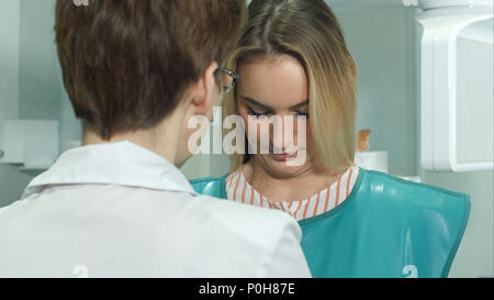 Jungen attraktiven weiblichen Patienten, der für zahnmedizinische Röntgensysteme Scan vorbereitet Stockfoto
