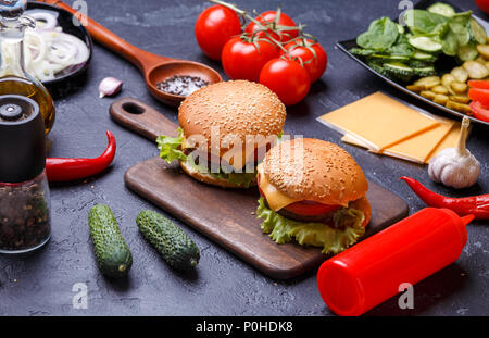 Foto von zwei Hamburger auf Holzbrett, Käse Stockfoto