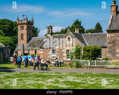 Dirleton Village Gardens, Scotland’s Gardens Scheme 2018, 9. Juni 2018. Dirleton Village, East Lothian, Schottland, Vereinigtes Königreich. Dorfbewohner öffnen ihre Gärten für die Öffentlichkeit als Teil der nationalen Gärten Schema. Besucher der offenen Gärten und des Blumenfestes vor der kirk-Halle, bei dem eine Frau an einem sonnigen Tag mit blauem Himmel eine ältere Frau in einen Rollstuhl schiebt Stockfoto