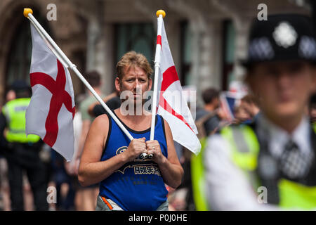 London, Großbritannien. 9. Juni, 2018. Ein Anhänger von Tommy Robinson, der ehemalige Führer der rechtsextremen English Defence League, hält zwei St George Flaggen am Rande der März für Tommy Robinson außerhalb der Downing Street. Tommy Robinson war für Missachtung des Gerichts nach der Verwendung von Social Media Details einer Versuchsperson zu Vertrag reporting Beschränkungen für Broadcast gefangengesetzt. Credit: Mark Kerrison/Alamy leben Nachrichten Stockfoto