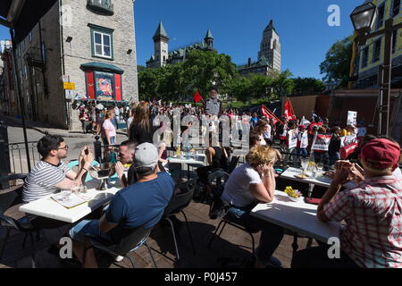Saguenay, Kanada. 8. Juni 2018. Kunden auf der Terrasse ansehen Anti-G7 Demonstranten zu Fuß in der Altstadt von Quebec City Streets. Credit: Patrice Lapointe/ZUMA Draht/Alamy leben Nachrichten Stockfoto