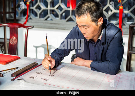 Yangzhou, Jiangsu, China. Chinesische Kalligraph bei der Arbeit. Stockfoto