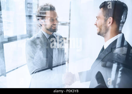 Junge lächelnde Geschäftsleute Händeschütteln nach dem Treffen im Büro Stockfoto