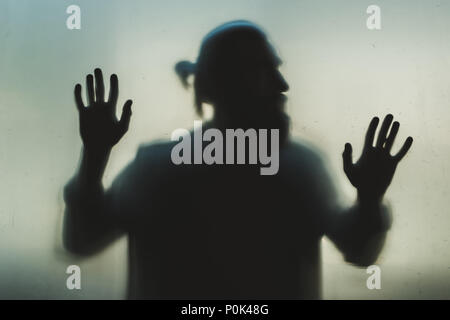Silhouette der Mann hinter Milchglas Stockfoto