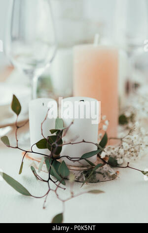 Die Nahaufnahme des stilvollen Tisch mit Kerzen, Blumen und Eukalyptus für rustikale Hochzeit Stockfoto