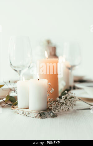 Die Nahaufnahme des stilvollen Tisch mit Kerzen, Weingläser und Blumen für rustikale Hochzeit Stockfoto