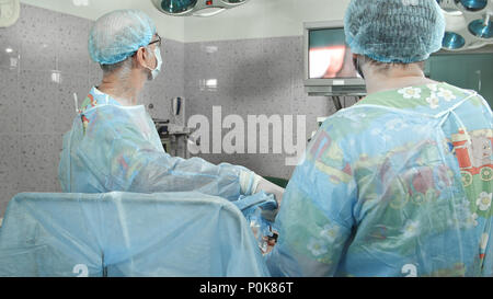 Chirurgen befolgen Sie die laparoskopische Chirurgie, auf Bildschirm Stockfoto