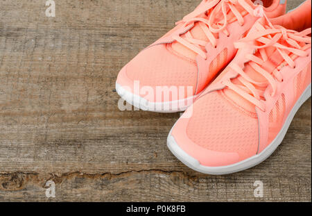 Rosa Sneakers auf Holz- Hintergrund. Studio Foto Stockfoto