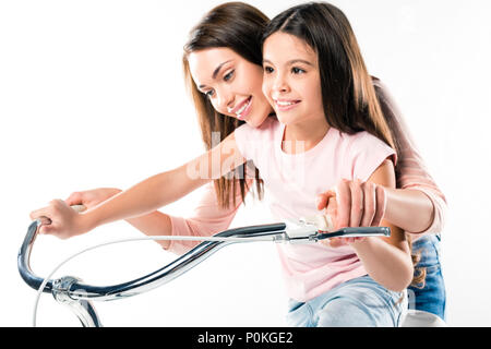 Mutter lehre Tochter mit dem Fahrrad isoliert auf weißem Stockfoto