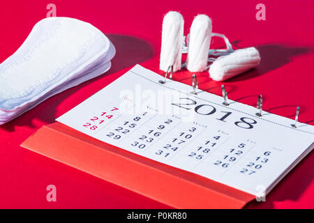 Tampons, tägliche Pads und Kalender auf Rot Stockfoto