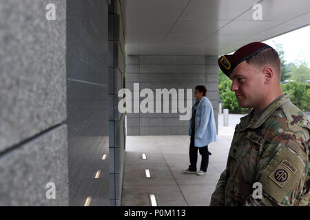 Spc. Christopher Smith, eine Infanterie Fallschirmjäger mit 2Nd Battalion, 504Th Parachute Infantry Regiment, 1st Brigade Combat Team, 82nd Airborne Division, liest die Inschrift auf einer Wand in der Normandie amerikanische Friedhof und Denkmal am 7. Juni 2018 bei Colleville-sur-Mer, Frankreich. Smith wurde gewählt als Vertreter für die 82Nd Airborne Division während der 74Th D-Day Gedenken zu dienen. Stockfoto