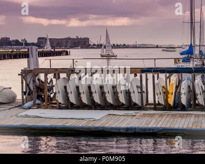 Wunderschöne Sonnenuntergang über Charles River reflektieren als Matrose sein Segelboot nimmt von Docking Stations Stockfoto