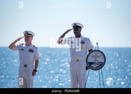 180606-N-UV-609-0243 ATLANTIK (6. Juni 2018) Kapitän Sean Bailey, Links, kommandierender Offizier der Flugzeugträger USS George H.W. Bush (CVN 77) und der Master Chief Marine Ratgeber Tyrone Jiles, rechts, handeln command Master Chief, render ein Gruß als Taps wird während einer Gedenkveranstaltung des 76. Jahrestags der Schlacht von Midway gespielt. Das Schiff ist im Gange, die Durchführung von routinemäßigen Übungen Träger bereit zu halten. (U.S. Marine Foto von Mass Communication Specialist 2. Klasse David Mora Jr.) Stockfoto