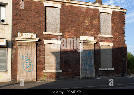 Verfallene Gebäude warten auf Abriss im Abendlicht mit einem blauen Himmel. Stockfoto