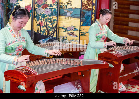 Yangzhou, Jiangsu, China. Junge Frauen spielen auf der Guzheng, schlanke West Lake Park. Stockfoto