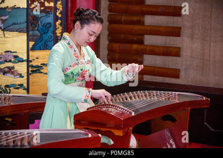 Yangzhou, Jiangsu, China. Junge Frau spielen auf der Guzheng, schlanke West Lake Park. Stockfoto