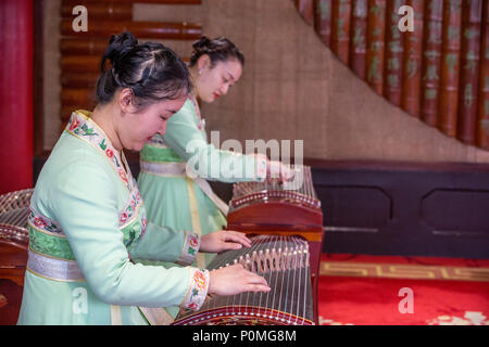 Yangzhou, Jiangsu, China. Junge Frauen spielen auf der Guzheng, schlanke West Lake Park. Stockfoto