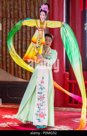 Yangzhou, Jiangsu, China. Junge Frau mit traditionellen Tanz mit Puppe und wirbelnden Stoff, schlanke West Lake Park. Stockfoto