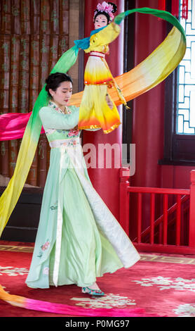 Yangzhou, Jiangsu, China. Junge Frau mit traditionellen Tanz mit Puppe und wirbelnden Stoff, schlanke West Lake Park. Stockfoto