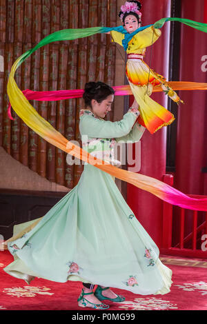 Yangzhou, Jiangsu, China. Junge Frau mit traditionellen Tanz mit Puppe und wirbelnden Stoff, schlanke West Lake Park. Stockfoto